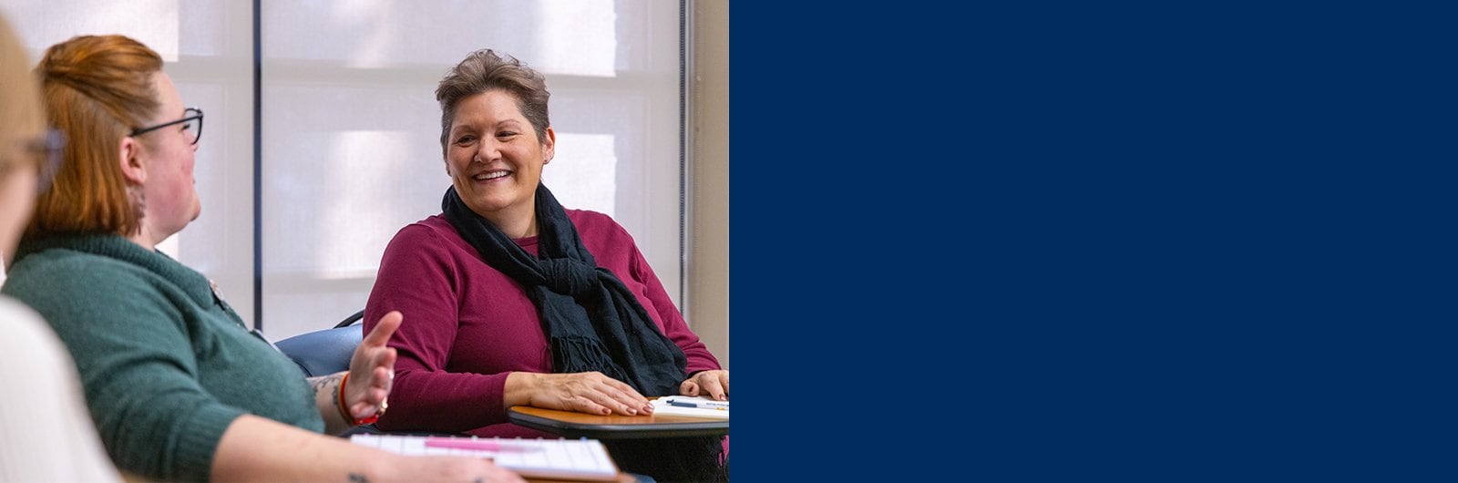 Photo of Jules Brown smiling and having conversation with hospital staff.