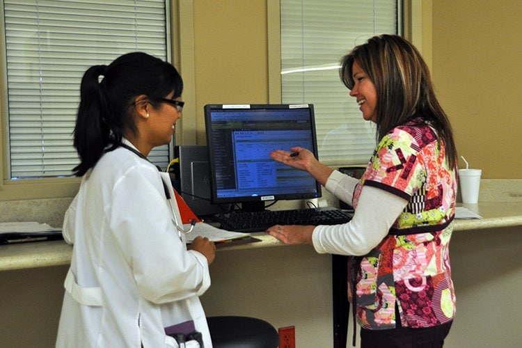 Dr. Marikit Parker with floor nurse discussing patient care.