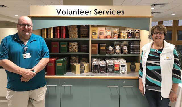 Photo of two volunteers standing near the Koeze Nuts holiday display.