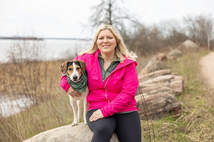 Photo of Brianna Bowen and her dog, sitting on a rock.