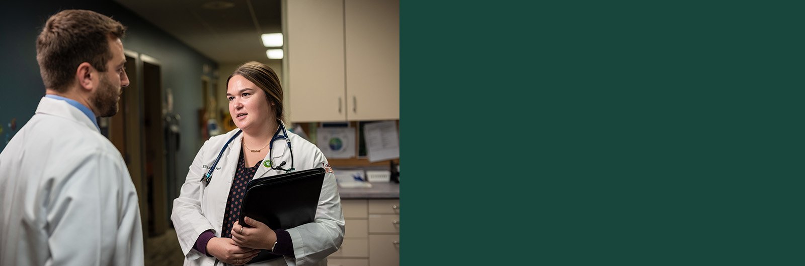 Elizabeth Martin, talking with another provider in the hallway of a hospital.