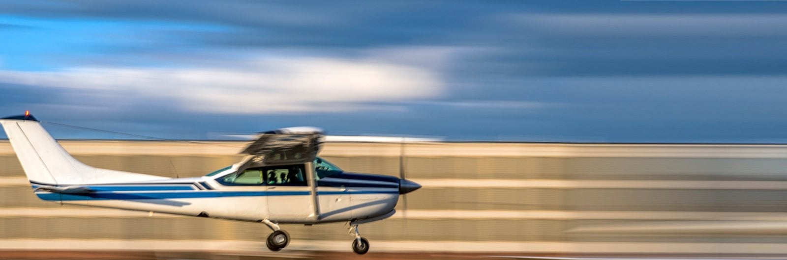 Photo of a single engine propeller aircraft taking flight.