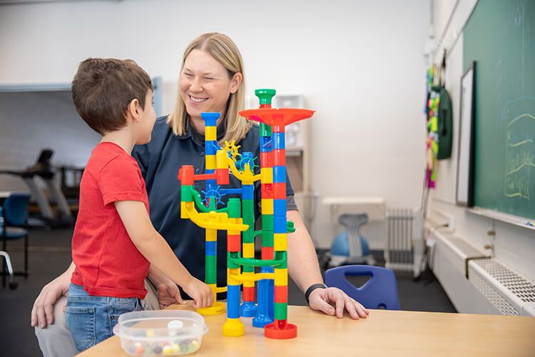 Photo of a therapist with a young boy at the Pediatric Center in Midland, Michigan.