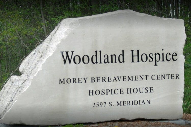 Photo of Woodland Hospice House rock sign with address.