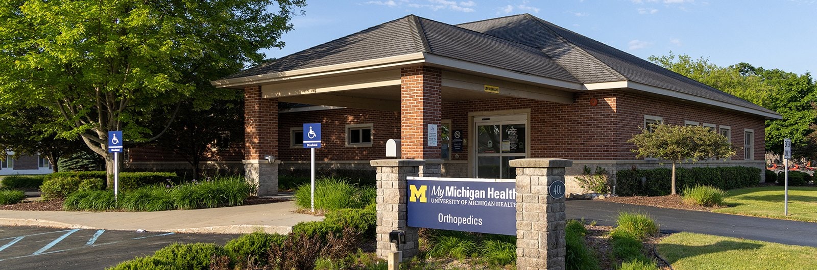 Exterior photo of Alpena Orthopedics office including parking spots and signage.