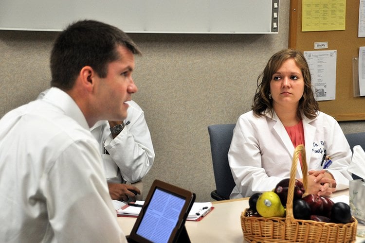 Photo of Dr. Sasha Savage joining in on educational discussion's with residents physician.