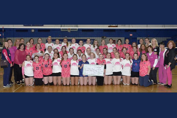 Image of high school volleyball teams wearing pink jerseys. 