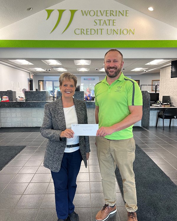 Ann Diamond, MyMichigan Foundation, accepts a check from Nick Montie at Wolverine State Credit Union.