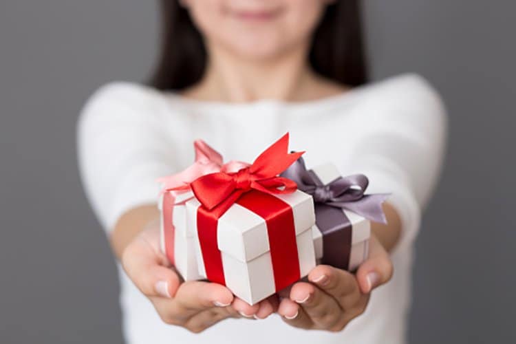 Photo of a young girl presenting gifts.