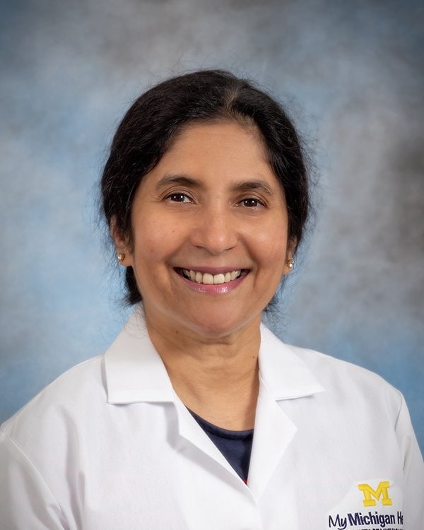 Professional headshot of Dr. Ishani wearing white lab coat.