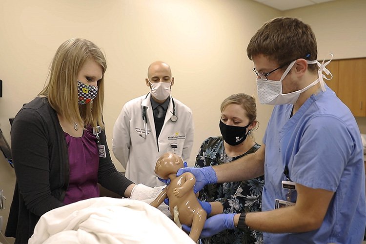 Photo of resident physicians practicing their delivery skills in our Simulation Center under the leadership of our faculty physicians.