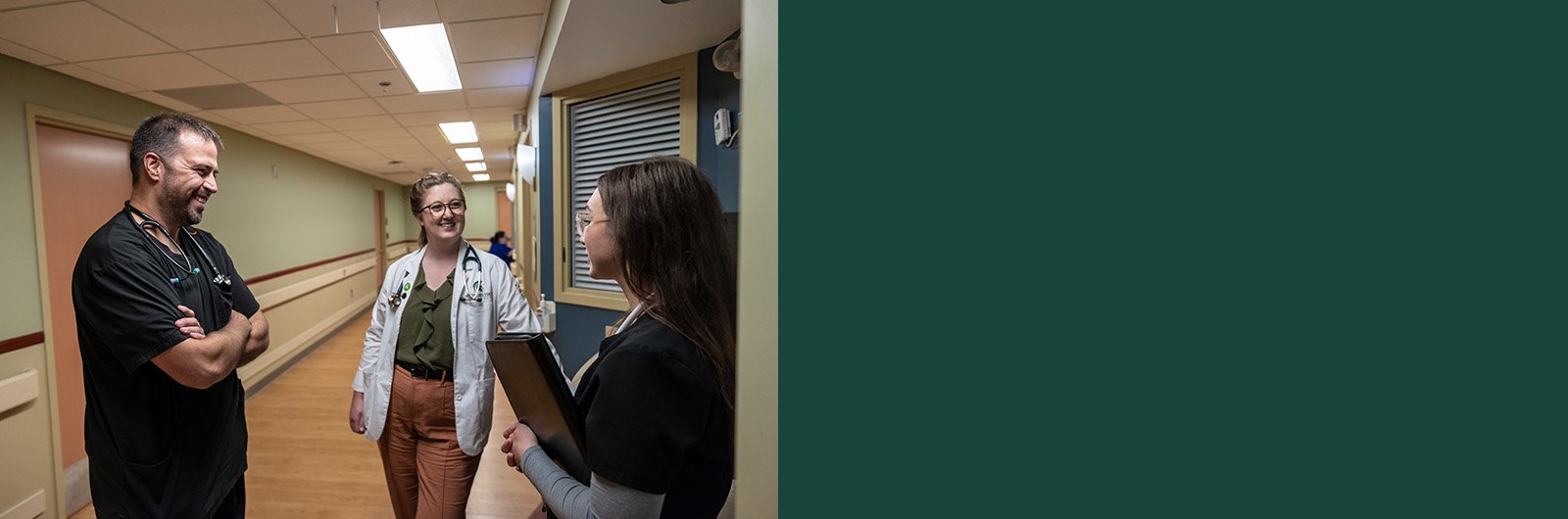 Kelsey Bean, talking with another provider in the hallway of a hospital.