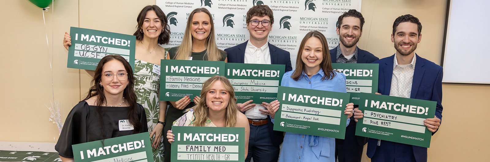 Photo of medical students holding their match signs. 