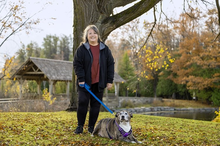 Diana Lacross standing by the water walking her dog.