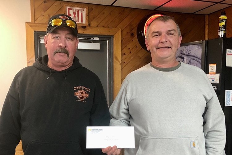 Image of third place winners holding their prizes from the clay shoot.