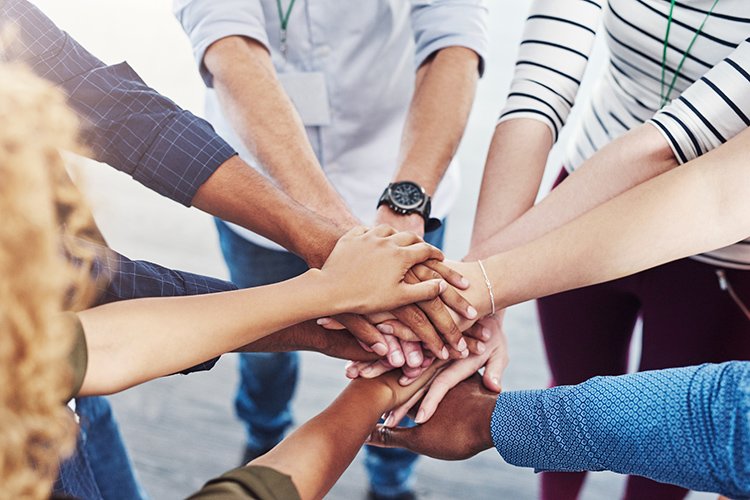 Photo of group with hands in the middle forming a circle